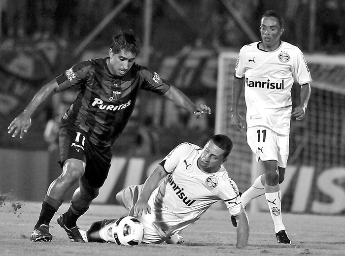 Maureen Franco, de Liverpool, Fabio Rosenback y Lúcio, de Gremio, anoche en el estadio Centenario · Foto: Javier Calvelo