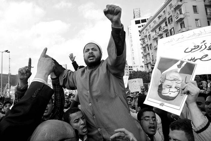 Un retrato del presidente egipcio Hosni Mubarak es sostenido con la cabeza hacia abajo
mientras un clérigo egipcio grita consignas al resto de los manifestantes durante una protesta en el centro de El Cairo. · Foto: Efe, Mohamed Omar