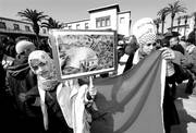 Dos jóvenes con una bandera y un cartel en el que se lee “No nos venderemos y no traicionaremos”, durante la manifestación
que se realizó ayer en Rabat, Marruecos, convocada para pedir reformas políticas y limitar los poderes del rey. 