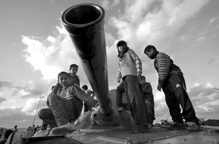 Niños juegan sobre un tanque frente a las oficinas de las fuerzas rebeldes en la ciudad portuaria de Bengasi, en Libia.  · Foto: Efe, Kim Ludbrook