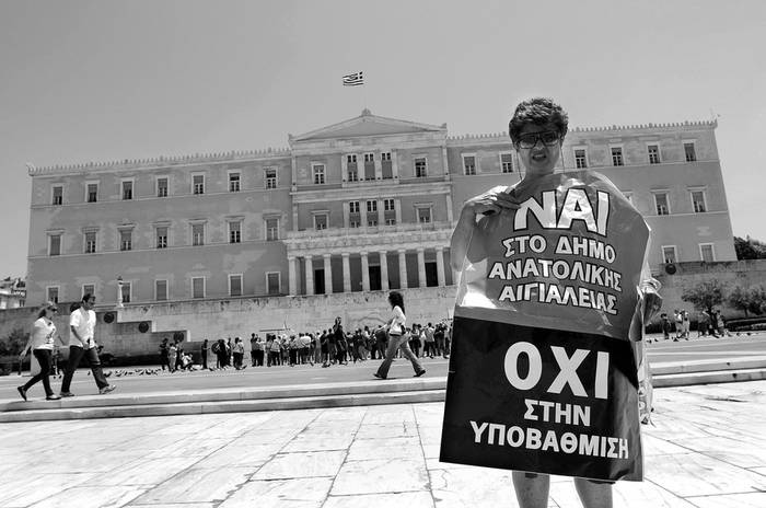 Atenienses se manifiestan frente al Parlamento en Atenas, contra el denominado Plan Kallikratis, que unificará municipios en entidades
más grandes y despedirá a hasta 30% de los funcionarios de la administración local. · Foto: Efe, Panagiotis Moschandreou