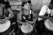 Niños que participan en actividades de la ong católica Catholic Welfare and Development tocan los tambores y cantan en la vereda de la institución.