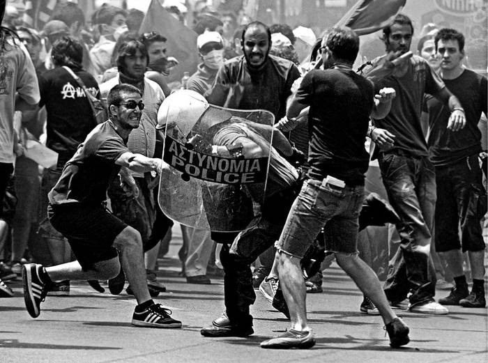 Enfrentamientos entre manifestantes y la policía, el 29 de junio, en el centro de Atenas, Grecia, durante una concentración
en el marco de la sexta huelga general convocada en lo que va del año. · Foto: Efe, Panagiotis Moschandreou
