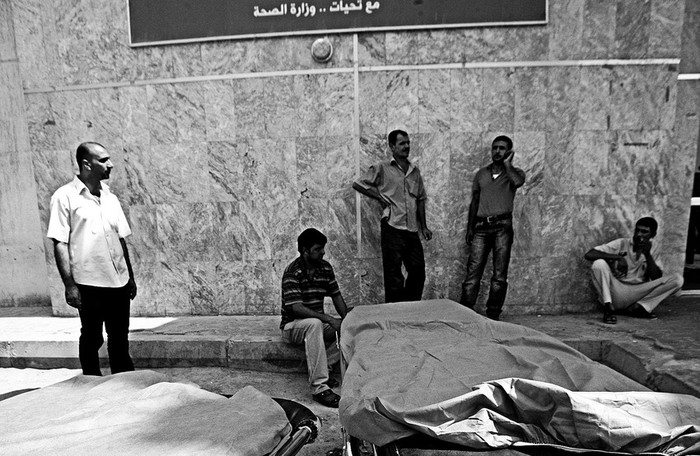 Familiares esperan a recoger los restos mortales de sus seres queridos
tras un atentado suicida ayer en un centro de reclutamiento militar en Bagdad, Irak. · Foto: EFE, Mohammed Jalil 