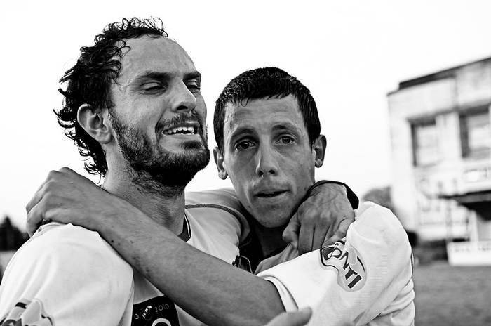 Santiago Sandoval y Ruben Suárez, de Nacional de Nueva Helvecia, el sábado, en el estadio Juan Antonio Lavalleja de Minas. · Foto: Nicolás Celaya