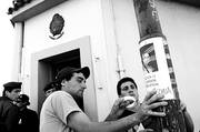 Amigos del joven Maiquel Martinho, asesinado el domingo en Piriápolis, colocan carteles con la foto de uno de los policías involucrados en el homicidio, ayer, frente a la sede judicial en la ciudad de Maldonado.