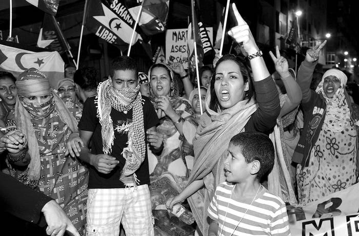 Decenas de manifestantes durante la concentración pro saharaui convocada ayer ante el consulado de Marruecos en Las Palmas de Gran Canaria en protesta por el desmantelamiento del campamento Gdaym Izik, en El Aaiún.  · Foto: efe, Elvira Urquijo a