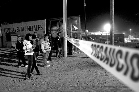 Un grupo de jóvenes observa el lugar donde otros siete fueron asesinados y uno más resultó herido durante un ataque de presuntos sicarios a una vivienda en la mexicana Ciudad Juárez. De las víctimas, que al parecer tenían entre 20 y 25 años, dos quedaron a un costado de un automóvil aparcado delante de la casa, tres más a unos metros de distancia y los dos restantes dentro de la vivienda · Foto: Efe, Alejandro Bringas Un grupo de jóvenes observa el lugar donde otros siete fueron asesinados y uno más resultó herido durante un ataque de presuntos sicarios a una vivienda en la mexicana Ciudad Juárez. De las víctimas, que al parecer tenían entre 20 y 25 años, dos quedaron a un costado de un automóvil aparcado delante de la casa, tres más a unos metros de distancia y los dos restantes dentro de la vivienda · Foto: Efe, Alejandro Bringas