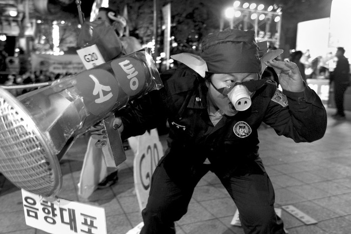 Un manifestante disfrazado de policía participa en una vigilia contra la cumbre del G-20, en Seúl. · Foto: Efe, Stephen Morrison