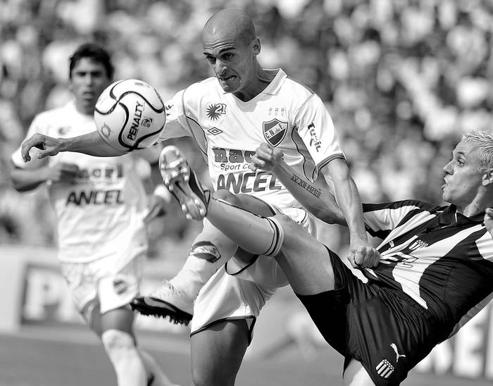 Mariano Pernía, de Nacional, y Fabián Estoyanoﬀ, ayer durante el clásico en el estadio Centenario. · Foto: Javier Calvelo