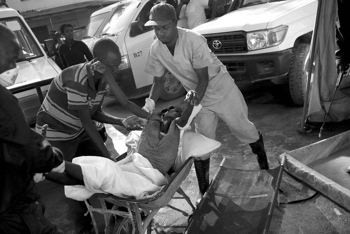Una mujer con síntomas de cólera es pasada a una camilla en el hospital Santa Catherine, ubicado en el distrito de Cité Soleil en Puerto Príncipe.  · Foto: Efe, Andrés Martínez Casares
