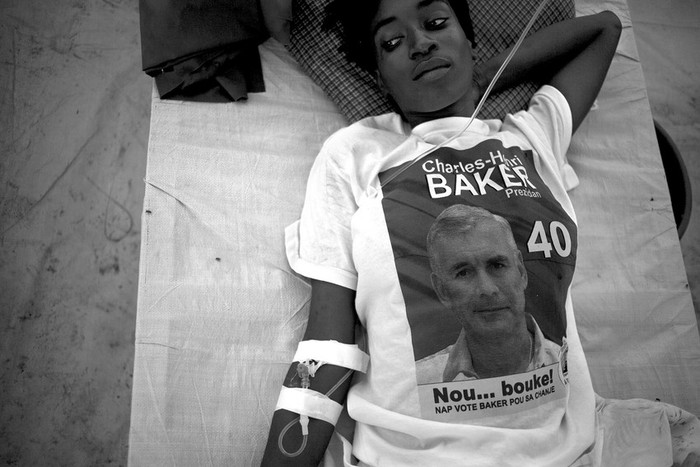 Paciente de cólera con una camiseta del aspirante presidencial Charles Henri Baker, en el hospital Bicentenaire, en Puerto Príncipe. · Foto: Efe, Andrés Martínez Casares