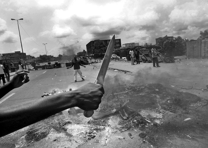 Manifestantes queman neumáticos y levantan barricadas para impedir el avance de las tropas leales a Laurent Gbagbo, en Abiyán, Costa de Marfil. · Foto: Efe, Legnan Koula