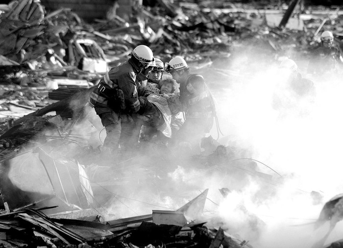 Bomberos rescatan a una sobreviviente del maremoto en la devastada ciudad de Natori, en la prefectura de Miyagi. · Foto: Efe, Stringer