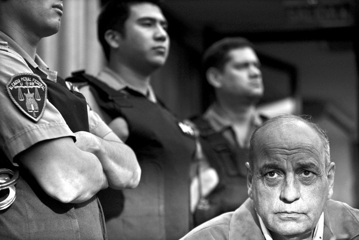 El ex agente civil de inteligencia del Ejército Raúl Guglielminetti es custodiado momentos antes de recibir su sentencia de 20 años de prisión, en Buenos Aires,
por crímenes cometidos durante la dictadura en la cárcel ilegal Automotores Orletti, pieza clave en la represión coordinada en el Cono Sur en los años 70. · Foto: EFE, Leo La Valle