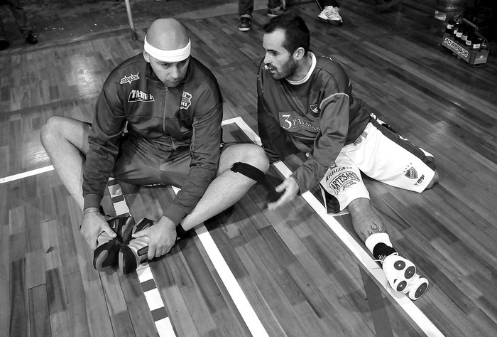 Gabriel Abratanski, de Goes, y Leo Vacca, de Nacional, anoche, mientras esperaban que se decidiera si se jugaba el partido tras la rotura del reloj en la cancha de Goes. · Foto: Javier Calvelo