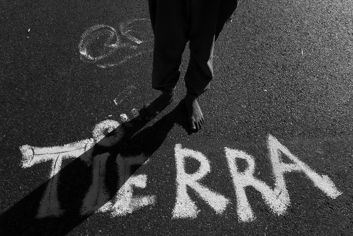 Los pies de una persona, cerca del letrero “Tierra”, son vistos ayer durante una protesta realizada por un centenar de aborígenes tobas,
en la avenida 9 de Julio de Buenos Aires. · Foto: Efe, Césaro de Luca