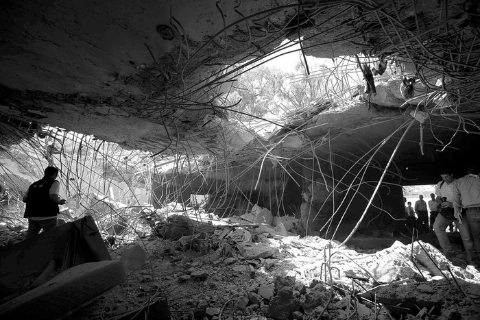 Varios periodistas caminan entre los escombros de la casa del líder libio, Muamar Gadafi, un día después de que fuera
alcanzada durante un bombardeo, en Trípoli.  · Foto: Efe, Stringer