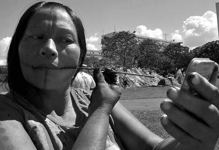 Una mujer indígena se maquilla mientras acampa junto a cientos de compañeros, en Brasilia, donde protestan contra proyectos
de desarrollo que el gobierno de Dilma Rousseff promueve en la Amazonia y en otras regiones del país habitadas por diversas tribus. · Foto: Efe, Elza Fiuza, Agencia Brasil