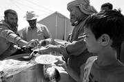 Refugiados libios el lunes obtienen su ración de comida en el recién abierto campo de refugiados de Dehiba, Túnez, destinado a acoger
familias libias que han huido de la violencia que vive el país
