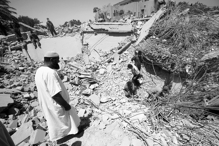 Miembros de equipos de rescate buscan sobrevivientes entre los escombros del complejo residencial de Al Khawaildi Al Hamadi atacado por la OTAN en Surnam, a 70 kilometros de Tripoli. El ataque destruyo la casa del
ministro del Interior, Khuwaylidi al-Hamidi, matando a dos de sus hijos y a una de sus esposas.  · Foto: Efe, Mohamed Messara