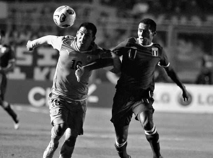 Maximiliano Pereira, de Uruguay, y Carlos Lobaton, de Peru, durante el partido jugado ayer, en el estadio del Bicentenario, en San Juan, Argentina. · Foto: Javier Calvelo