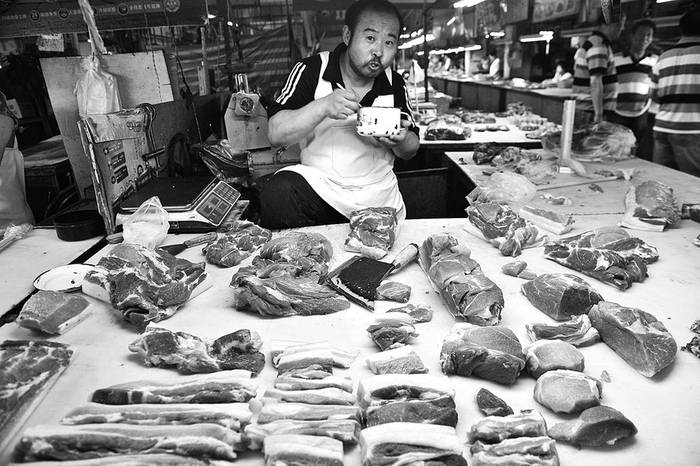 Un hombre vende carne de cerdo en un puesto del mercado en Shenyang, ayer, en China. · Foto: efe, mark