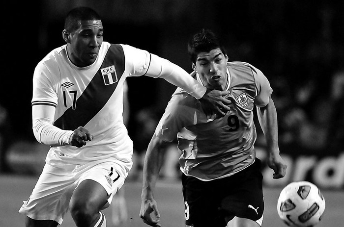 Giancarlo Carmona de Perú y Luis Suárez, anoche en el estadio Único de La Plata. · Foto: Javier Calvelo