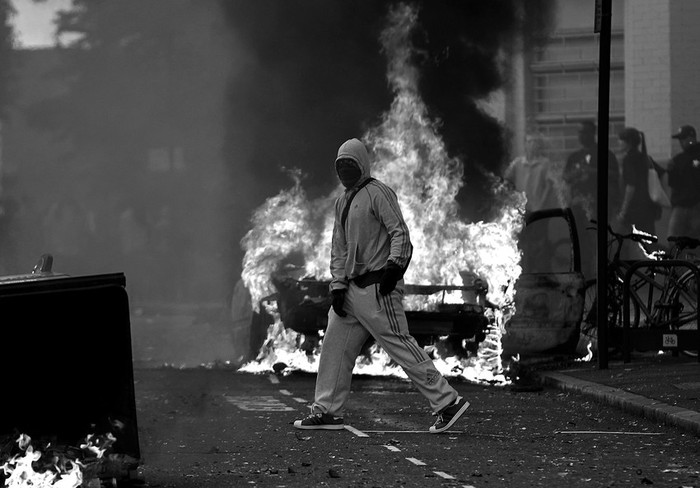 Un hombre encapuchado cruza una calle cortada por contenedores ardiendo en el barrio de Hackney, al este de Londres. Hackney fue ayer escenario de nuevos enfrentamientos entre fuerzas de seguridad y manifestantes,
en barrios pobres afectados por la crisis. El desencadenante fue la muerte de un joven negro el jueves a manos de la Policía. · Foto: Efe, Kerim Okten Un hombre encapuchado cruza una calle cortada por contenedores ardiendo en el barrio de Hackney, al este de Londres. Hackney fue ayer escenario de nuevos enfrentamientos entre fuerzas de seguridad y manifestantes,
en barrios pobres afectados por la crisis. El desencadenante fue la muerte de un joven negro el jueves a manos de la Policía. · Foto: Efe, Kerim Okten