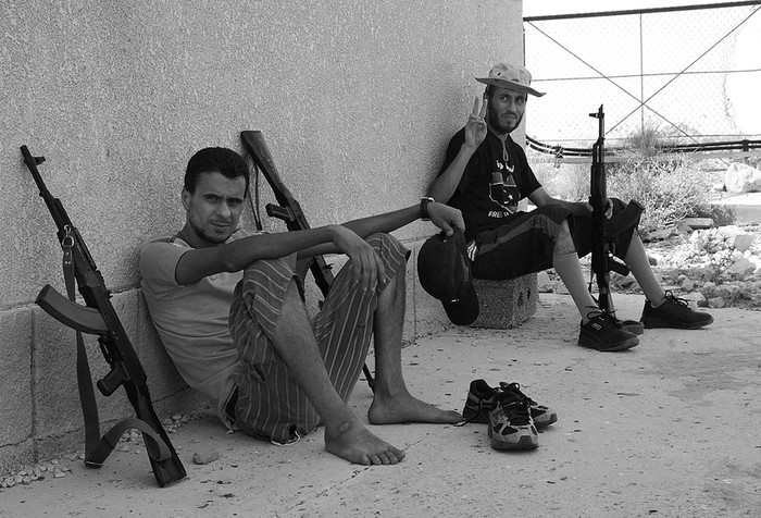 Milicianos rebeldes libios descansan a la sombra en un lugar de la ciudad de Bani Walid, una de las que todavía resisten
el avance rebelde.  · Foto: Efe, Javier Martín