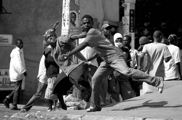 Jóvenes arrojan piedras contra un grupo de cascos azules de la Minustah que custodian los alrededores del Consejo Electoral Provisional
(CEP), en el suburbio de Petion Ville, en Puerto Príncipe. · Foto: Efe, Andrés Martínez Casares