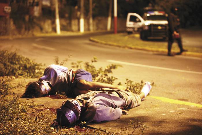 Los cuerpos de dos hombres, encontrados por la Policía estatal en la avenida Paseo Libertad, centro de Veracruz, 6 de diciembre de 2011. Foto: Félix Márquez.