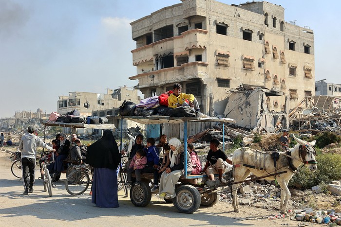 Palestinos desplazados de los refugios en Beit Hanoun cruzan la carretera principal hacia Jabalia, en el norte de la Franja de Gaza. · Foto: Omar Al-Qattaa, AFP