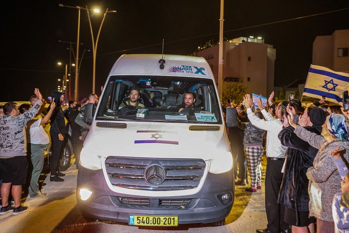 Vehículo que transporta rehenes liberados por Hamas se dirige a una base militar en Ofakim, en el sur de Israel (26.11.2023). · Foto: Menahen Kahana, AFP