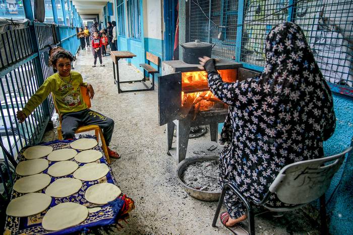 Una mujer palestina cocina pan en una escuela utilizada como refugio, en la ciudad de Gaza (27.11.2023). · Foto: Omar El-Qattaa, AFP