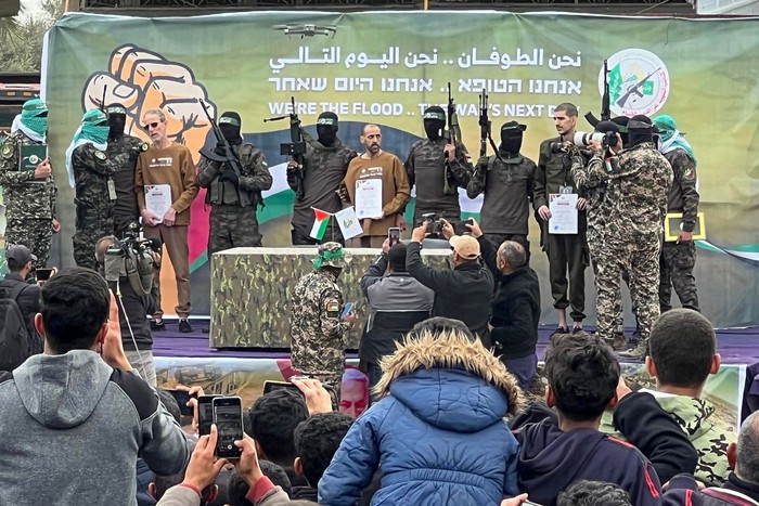 Combatientes palestinos de Hamas escoltan a los rehenes israelíes antes de entregarlos a un equipo de la Cruz Roja, en Deir el-Balah, el 8 de febrero, en el centro de Gaza. · Foto: Bashar Taleb, AFP