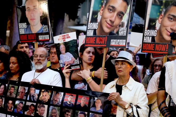 Manifestantes sostienen retratos de los rehenes israelíes capturados por militantes palestinos, este lunes, frente a la residencia de Benjamin Netanyahu, en Jerusalén. · Foto: Menahen Kahana, AFP