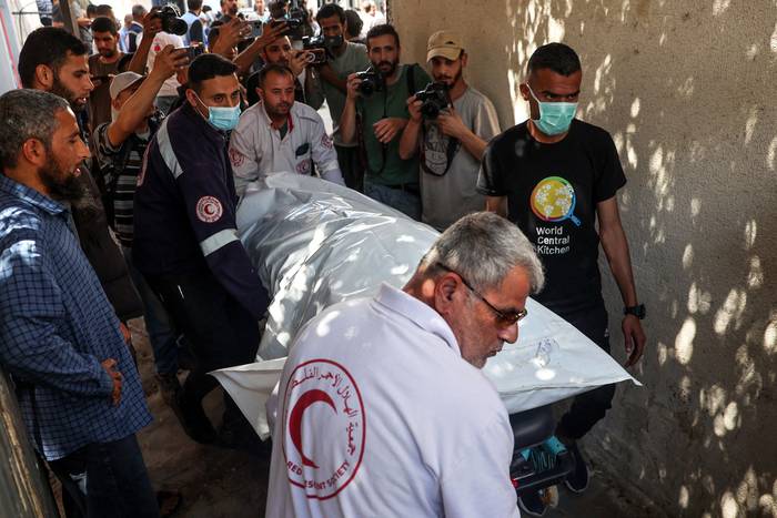 El cuerpo de uno de los miembros del grupo de ayuda estadounidense World Central Kitchen es transportado fuera de la morgue de un hospital, el 3 de abril, en Rafah, Franja de Gaza. · Foto: Said Khatib, AFP