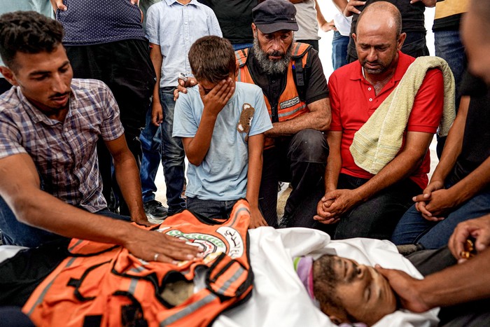 Familiares y miembros de la Defensa Civil Palestina, el 16 de julio, junto al cuerpo de su colega Bilal Ramadan Farhan, quien murió a causa de las heridas sufridas en el bombardeo israelí de la zona de Al-Mawasi. · Foto: Bashar Taleb, AFP