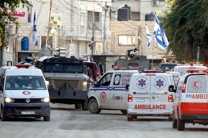 Fuerzas israelíes en vehículos blindados detienen ambulancias palestinas para bloquear una carretera durante una incursión militar, el 21 de enero, en Yenin, en la Cisjordania ocupada. · Foto: Jaafar Ashtiyeh / AFP