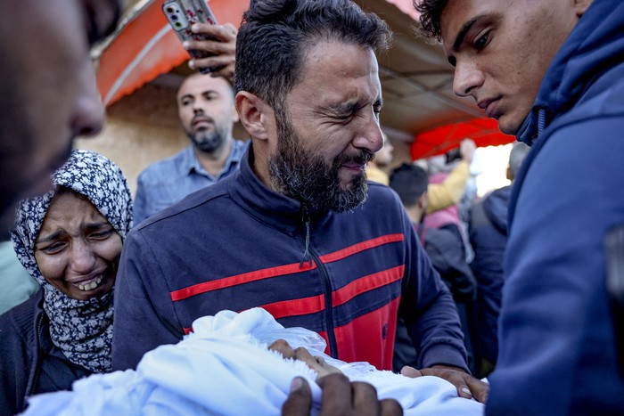 Un palestino lleva el cuerpo de un bebé muerto en un ataque israelí en el Hospital de los Mártires de Al Aqsa en Deir Al-Balah, el 17 de noviembre, en la Franja de Gaza. · Foto: Bashar Taleb, AFP