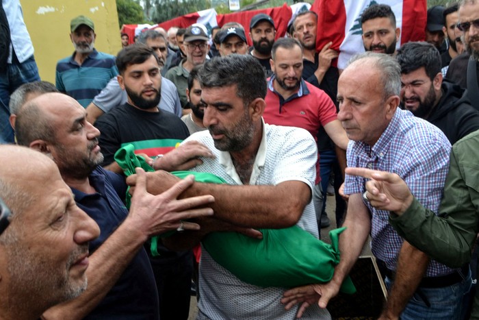 Un hombre lleva el cuerpo de un niño que murió en un ataque israelí, el 14 de octubre, contra la aldea de Aito, en el norte de Líbano. · Foto: Fathi Al-Masri, AFP