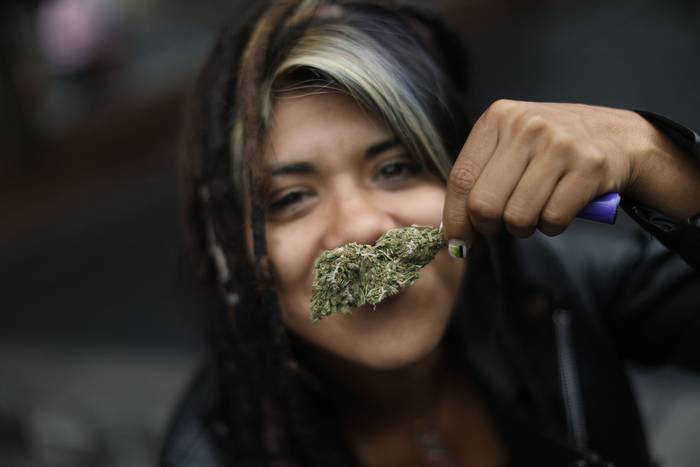 Una mujer muestra un cogollo de marihuana, ayer, afuera de la Suprema Corte de Justicia de la Nación, en Ciudad de México.
 · Foto: Sáshenka Gutiérrez, Efe