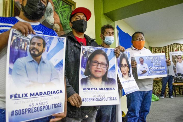 Representantes de grupos de nicaragüenses exiliados en Costa Rica, sostienen retratos de opositores al gobierno de Nicaragua encarcelados, luego de una conferencia de prensa, el 28 de marzo, en San José. · Foto: Ezequiel Becerra, AFP
