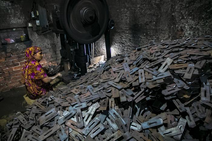 Una mujer migrante trabaja en un entorno insalubre y riesgoso en una fábrica de casilleros en Dhaka, Bangladesh, el 30 de agosto de 2022. · Foto: Kazi Salahuddin Razu, AFP
