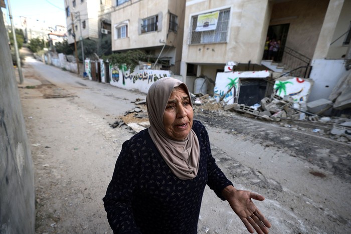 Una mujer palestina camina por una calle dañada durante una redada del ejército israelí, el 28 de agosto, en el campamento de Nur Shams, cerca de la ciudad de Tulkarem, en la Cisjordania ocupada por Israel. · Foto: Jaafar Ashtiyeh / AFP