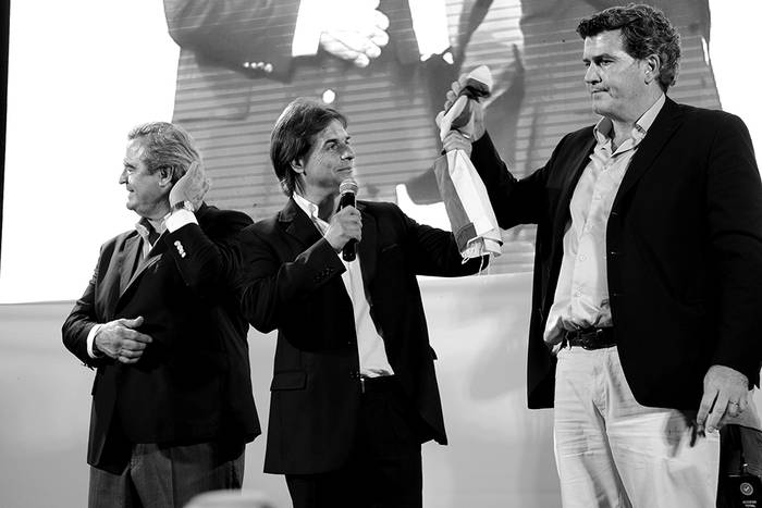 Jorge Larrañaga, Luis Lacalle Pou y Pedro Bordaberry, ayer en el acto final en la rambla de Ciudad Vieja en Montevideo, luego de que se conocieran los resultados de la elección nacional. / Foto: Javier Calvelo