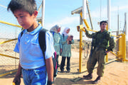 Niños del pueblo palestino de Jbara regresan de la escuela, que quedó separada de su pueblo por la valla que construyó el gobierno israelí y que es controlada por el ejército. 28 de octubre de 2003. Foto: Quique Kierszenbaum