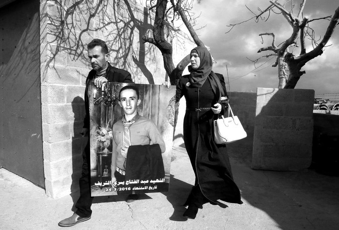 Rajaa y Yousri, madre y padre de Abdul Fatah al Sharif, llevan el retrato de su hijo por las calles de Hebrón. Foto: Hazem Bader, Afp