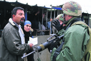 Una pareja de palestinos discute con soldados israelíes que les impiden cruzar el puesto de control de Hawara, en Nablus, Cisjordania. 5 de noviembre de 2006. Foto: Quique Kierszenbaum